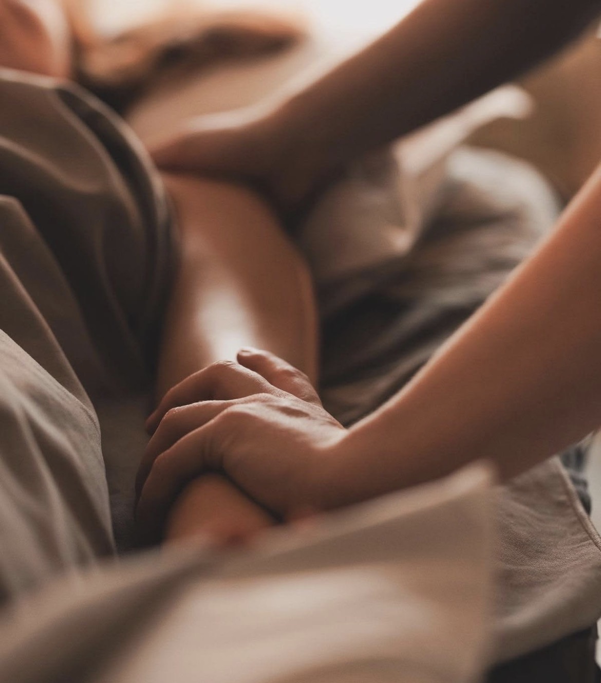 Hands gently holding a client's arm during a relaxation massage in Esther's Narangba studio